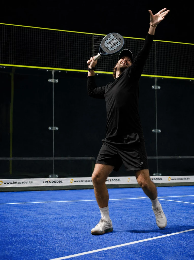 Player serving on a Let's Padel court